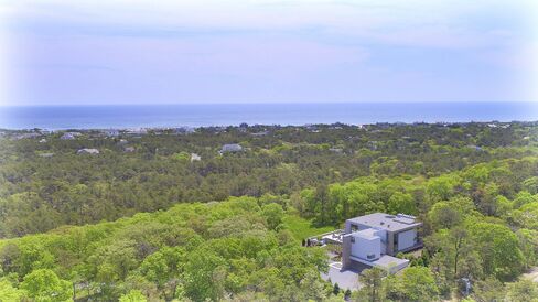 The house is situated on top of a hill, with views of the ocean.