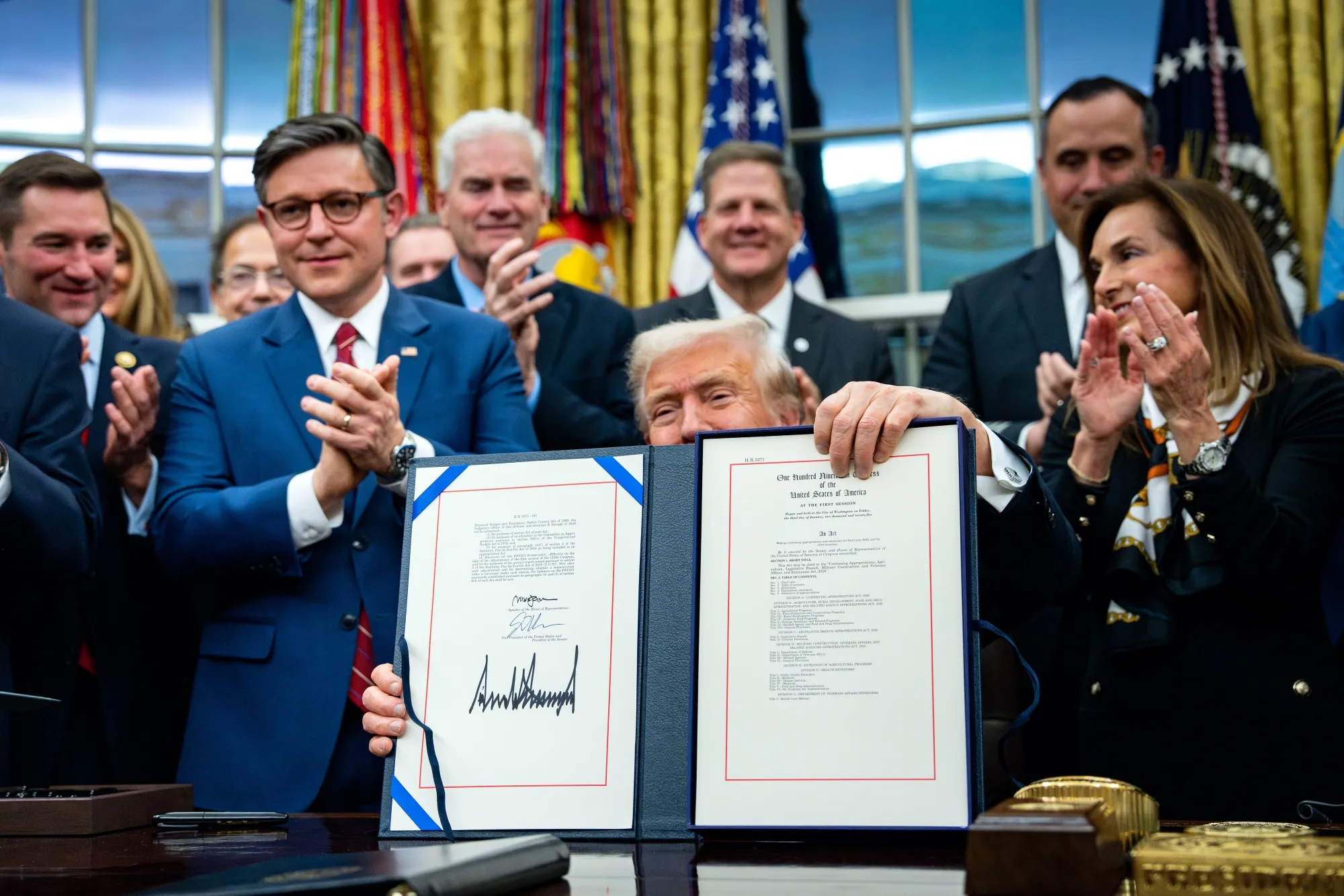 President Donald Trump displays signed funding legislation to reopen the US government, on Nov. 12.