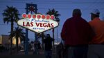 Visitors stand for a photograph under a sign in Las Vegas on Feb. 20, 2016.
