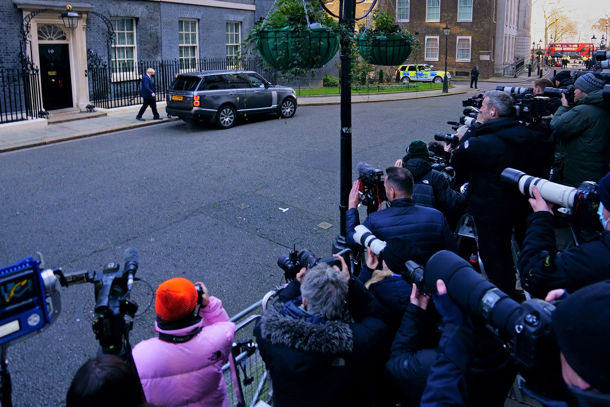 Members of the media photograph U.K. Prime Minister Boris Johnson leaving 10 Downing Street on January 19, 2022.