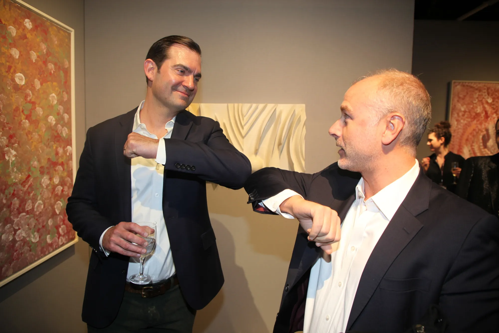 Lowell Pettit, an art consultant, and David Schrader of Sotheby’s, demonstrate a coronavirus-conscious greeting.