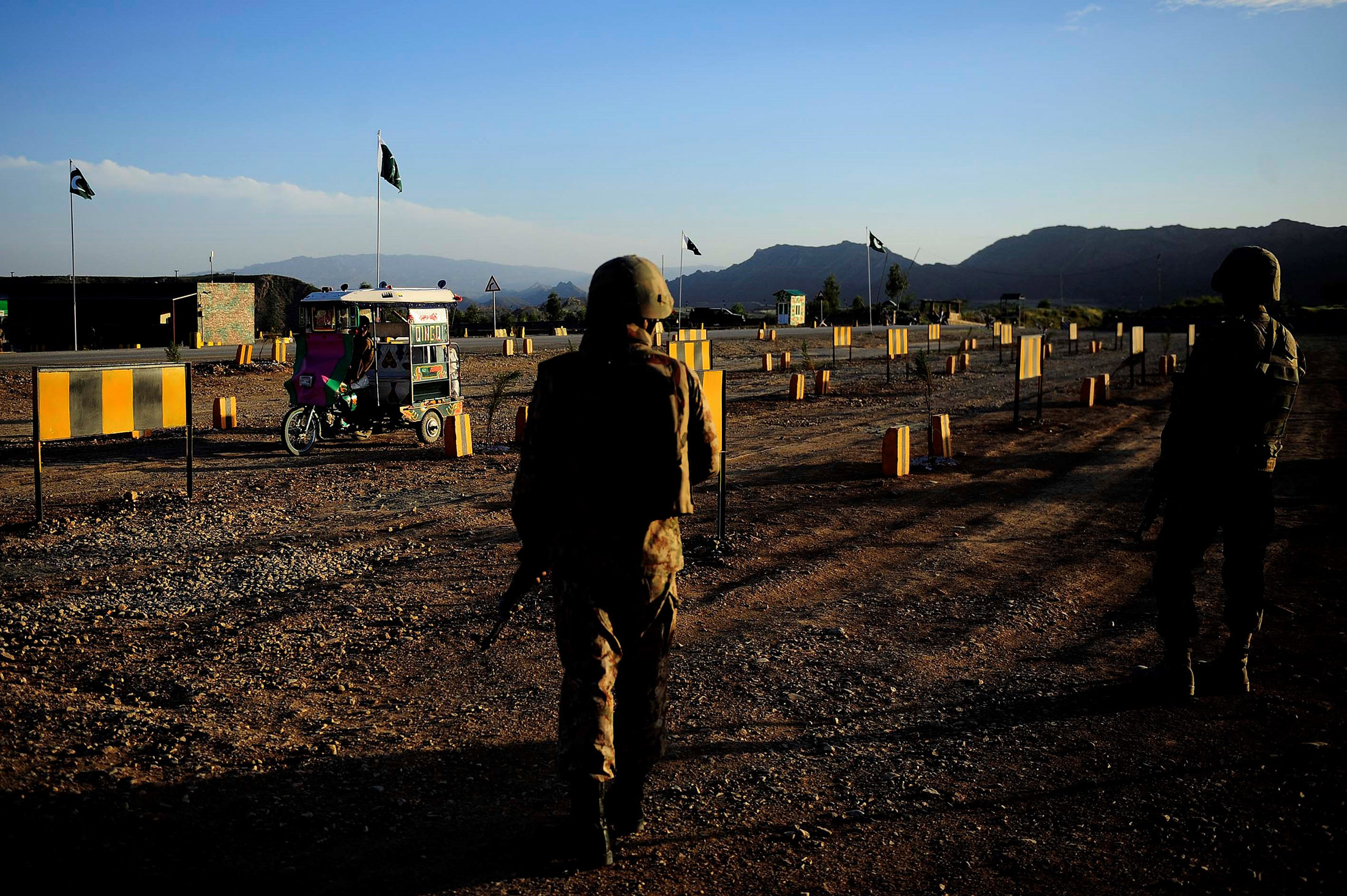 NORTH WAZIRISTAN, PAKISTAN - APRIL 20: Soldiers stand guard as a citizen passes through with his vehicle at the Saidgai military check point in the Afghanistan border of North Waziristan, Pakistan on April 20, 2016. Large-scale military operations against Taliban militants, have been launched since June 2014, have reached to the final stage. Over 3500 militants were neutralized during the operations and some of the civilians that had to leave homes because of operation, have started to return as all the entries and exits to area are controlled by this check point. North Waziristan - one of Pakistans seven semi-autonomous tribal regions - has seen numerous clashes between the army and Taliban since June of 2014 amid a full-scale military onslaught. The just-concluded military operation also served to displace some one million tribesmen from North Waziristan, nearly 30 percent of whom have since returned to their homes.
