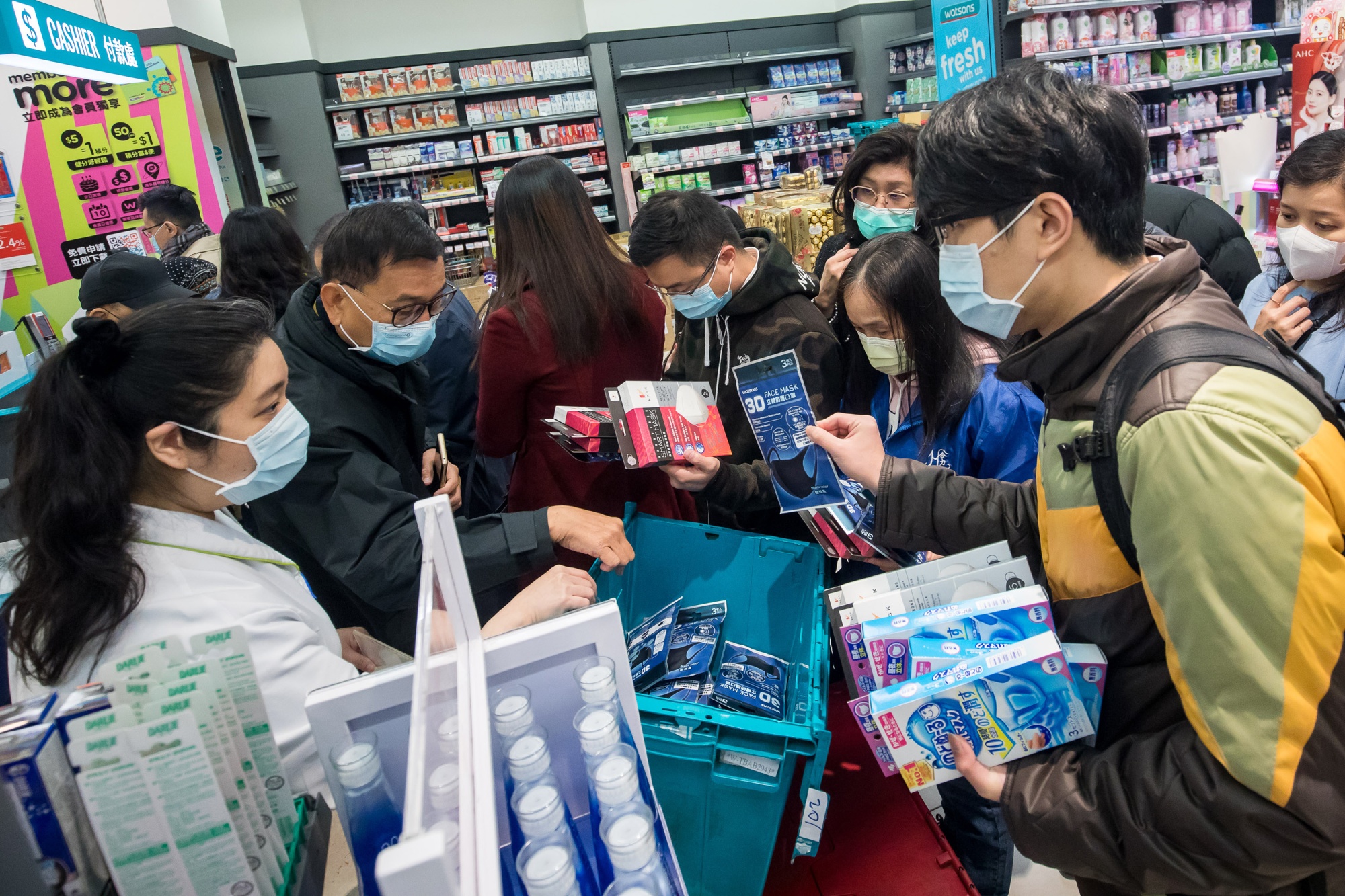 People wait in line to purchase protective masks at a Watsons store in Hong Kong.