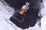 A bulldozer moves piles of coal at the Osinnikovskaya coal mine in Osinniki, Russia.