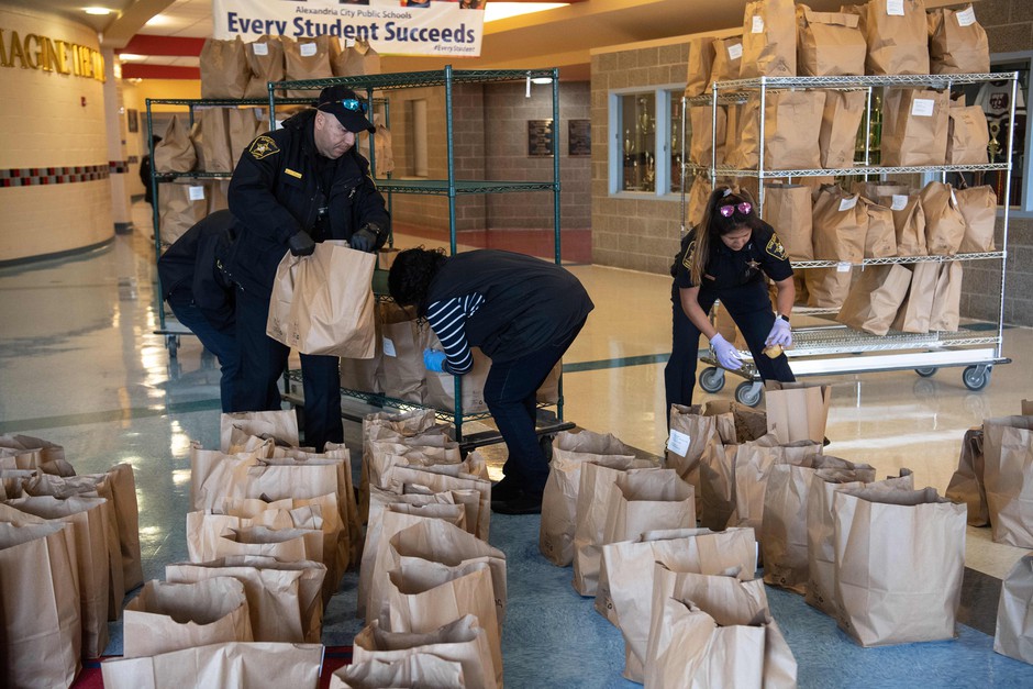 Volunteers prepare bagged meals for students while schools are closed in Alexandria, Virginia.