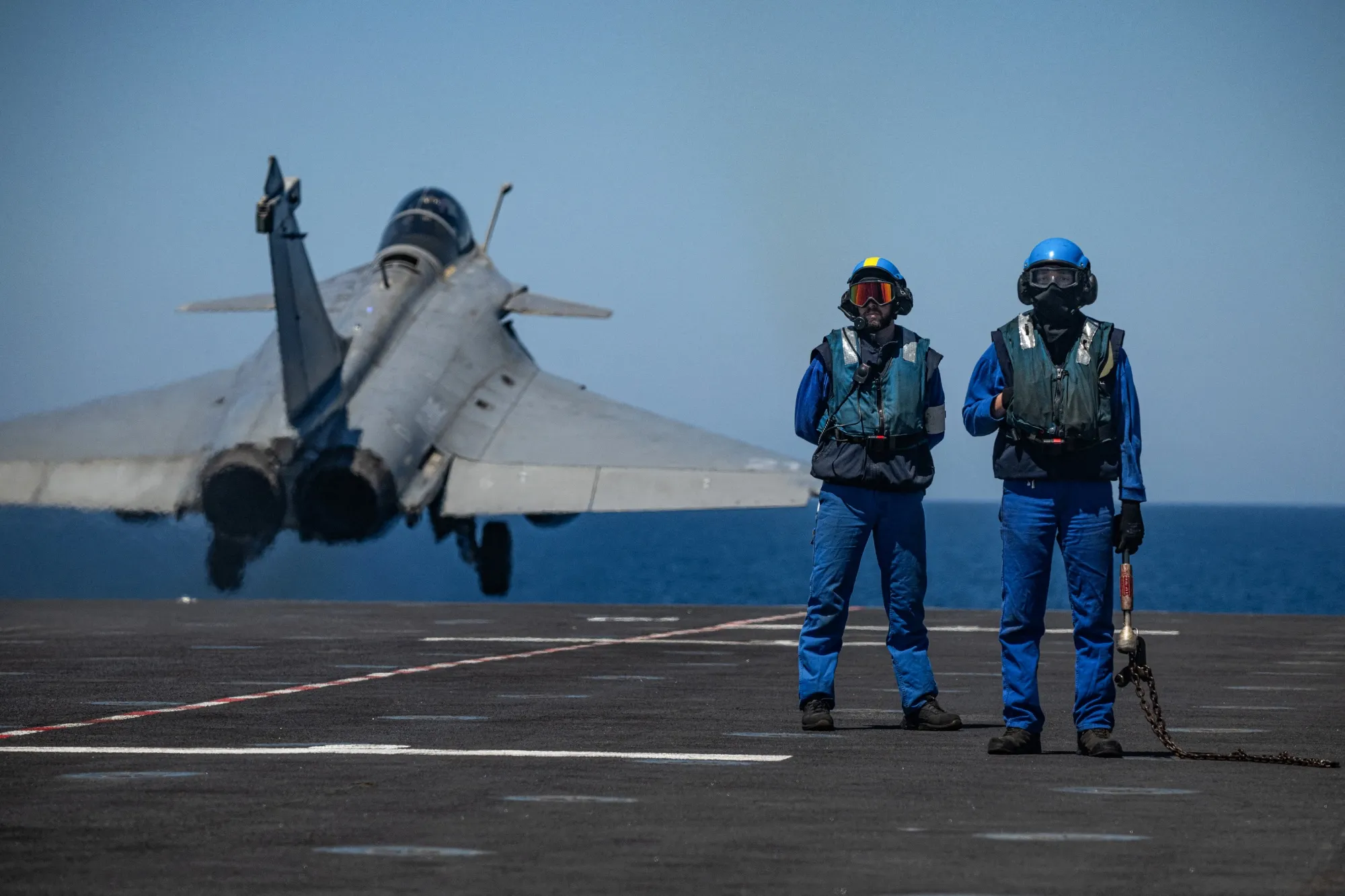Military personnel stand guard as a rafale fighter jet takes off during a NATO military exercise off the coast of the Greek island of Crete&nbsp;on April 27.