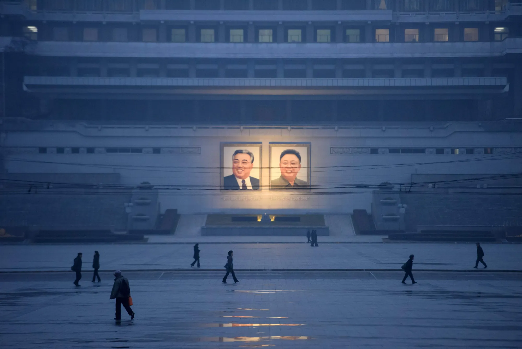 Pedestrians walk&nbsp;past portraits of late North Korean leaders Kim Il Sung and Kim Jong Il&nbsp;in Pyongyang.