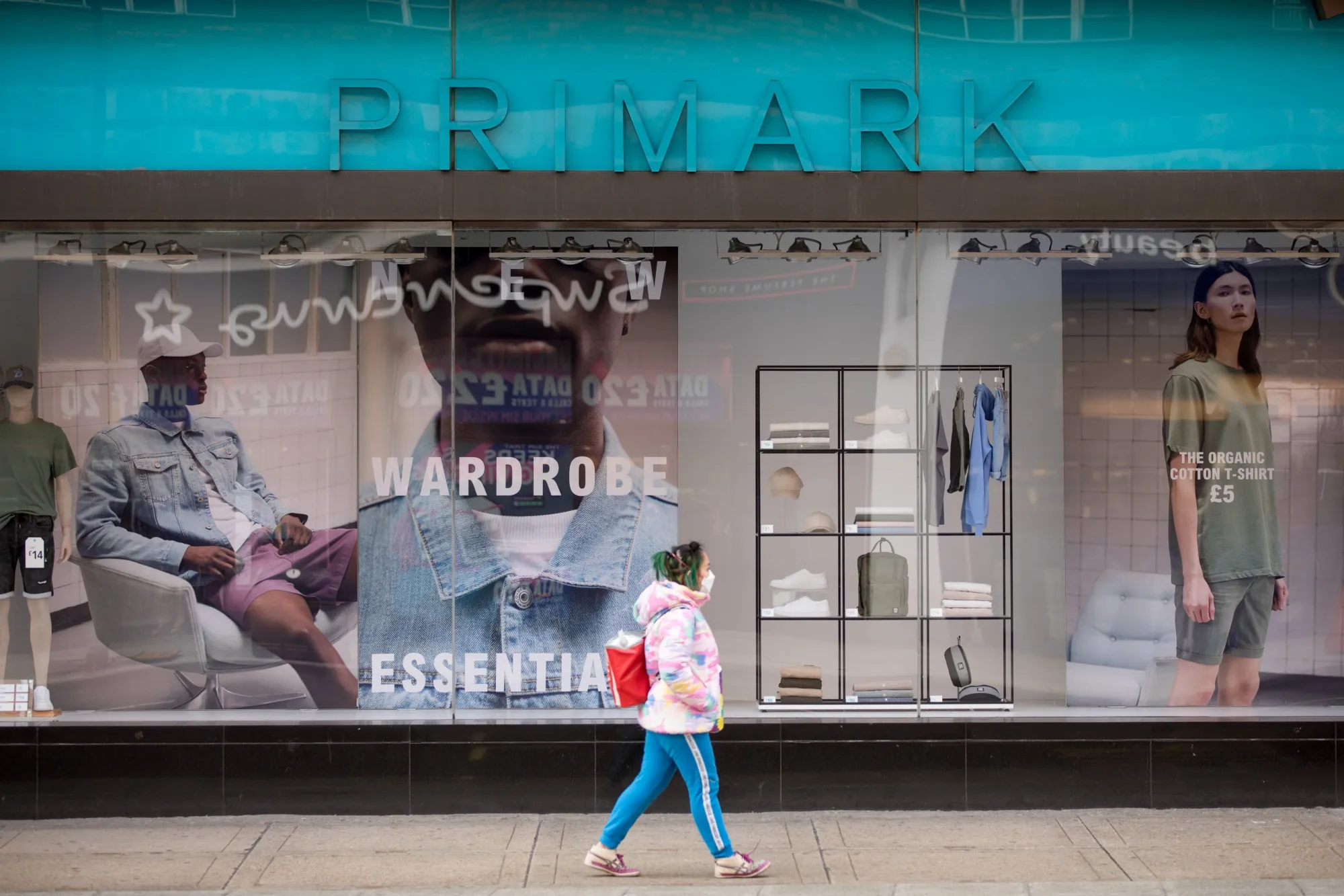 A pedestrian wearing a protective face mask walks past a closed Primark store on Oxford Street in London on March 30.