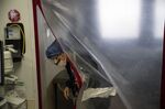 A nurse exits a barrier of a patient's room in the ICU at University Hospital in Newark, New Jersey.