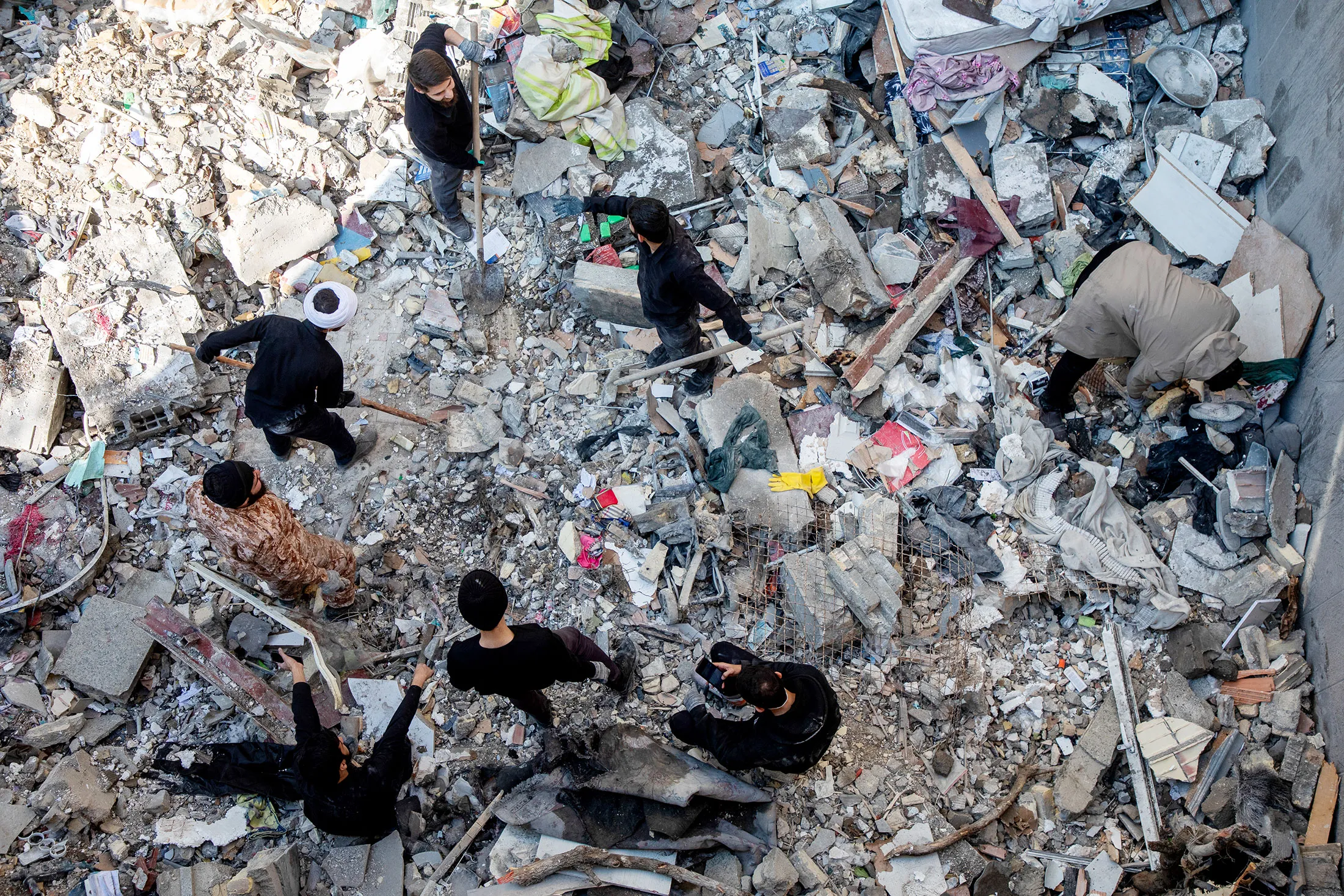 People sift through rubble following a strike in Tehran, on March 31.