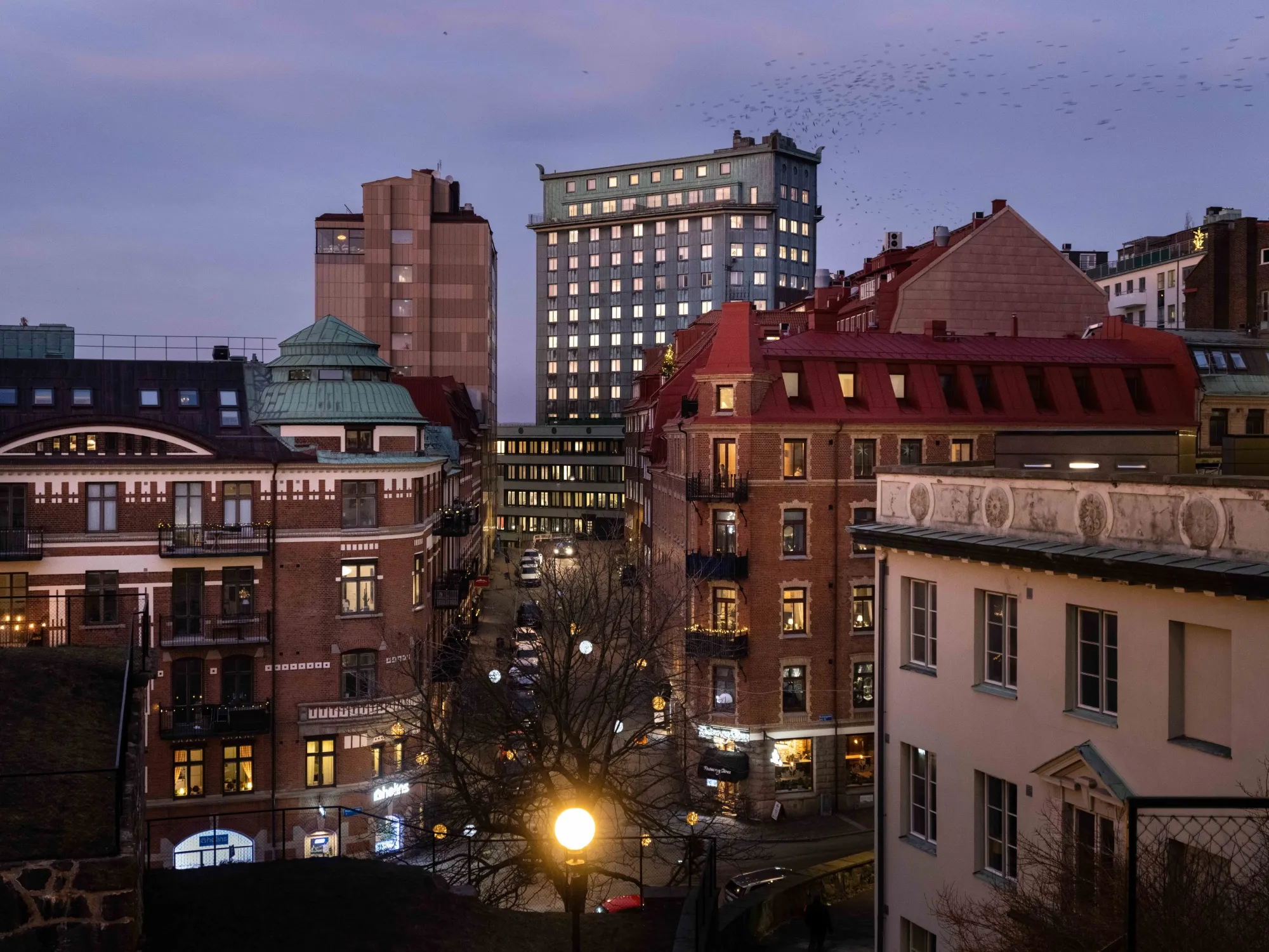 Electric lights on in homes and businesses at dusk in Gothenburg, Sweden.