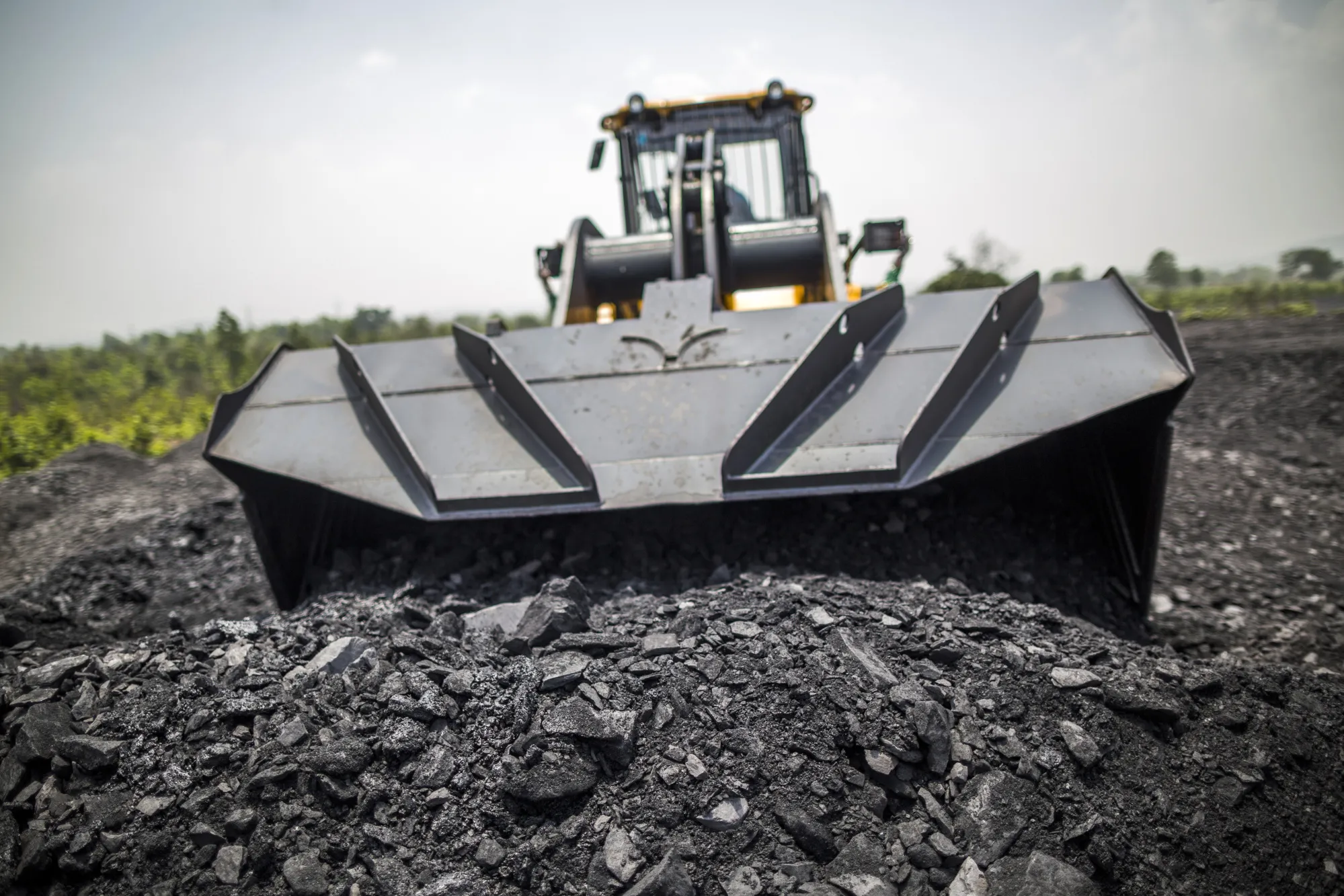 A front loader moves coal