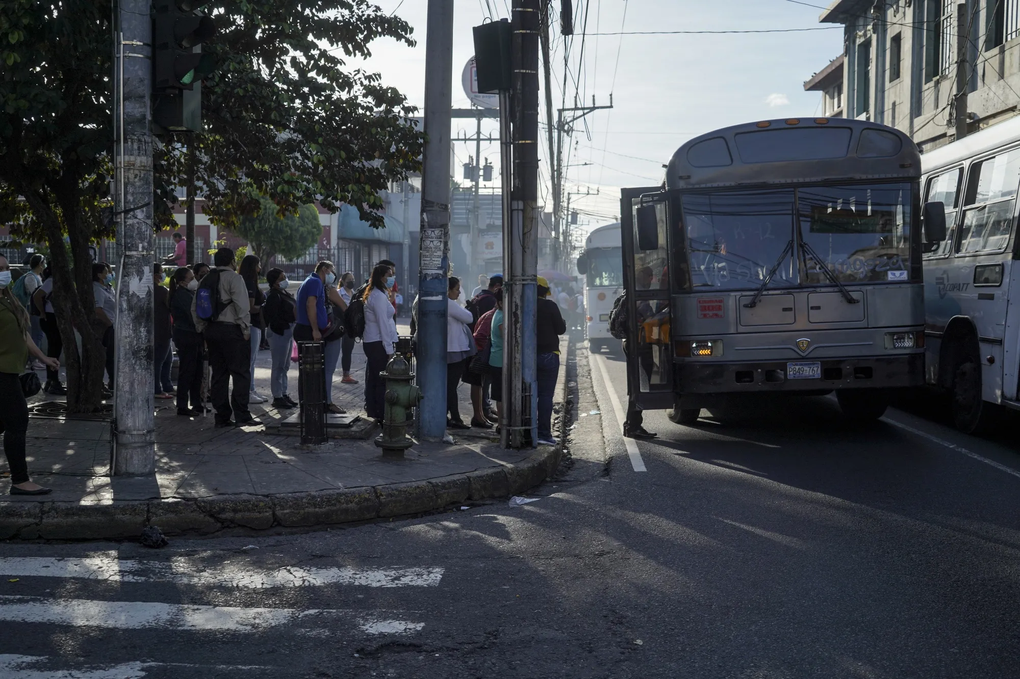 Commuters wait in line to board a bus in San Salvador, El Salvador.