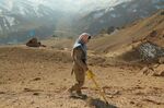 An Afghan deminer scans a combat zone dating back to the Soviet invasion at Ahangaran in the central Afghan province of Bamiyan.