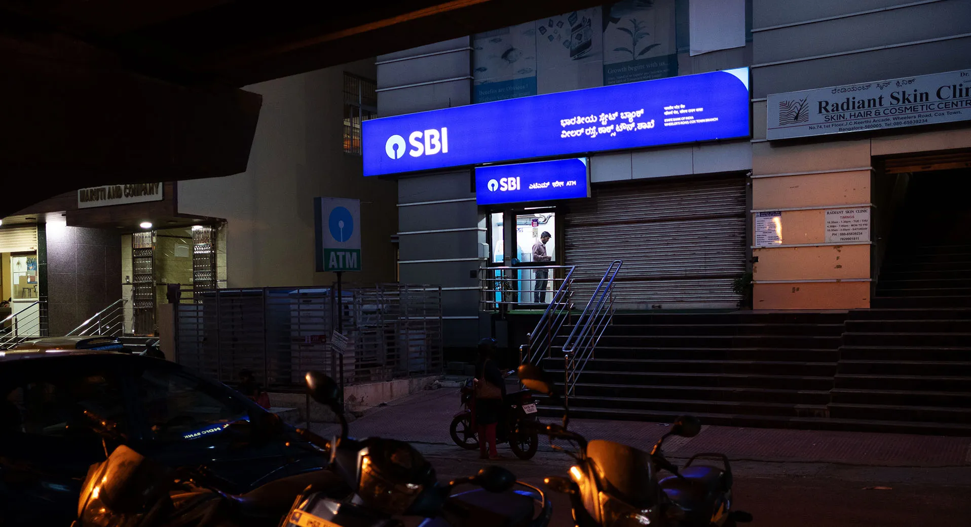 A customer uses an automated teller machine at a State Bank of India branch at night in Bengaluru, India.