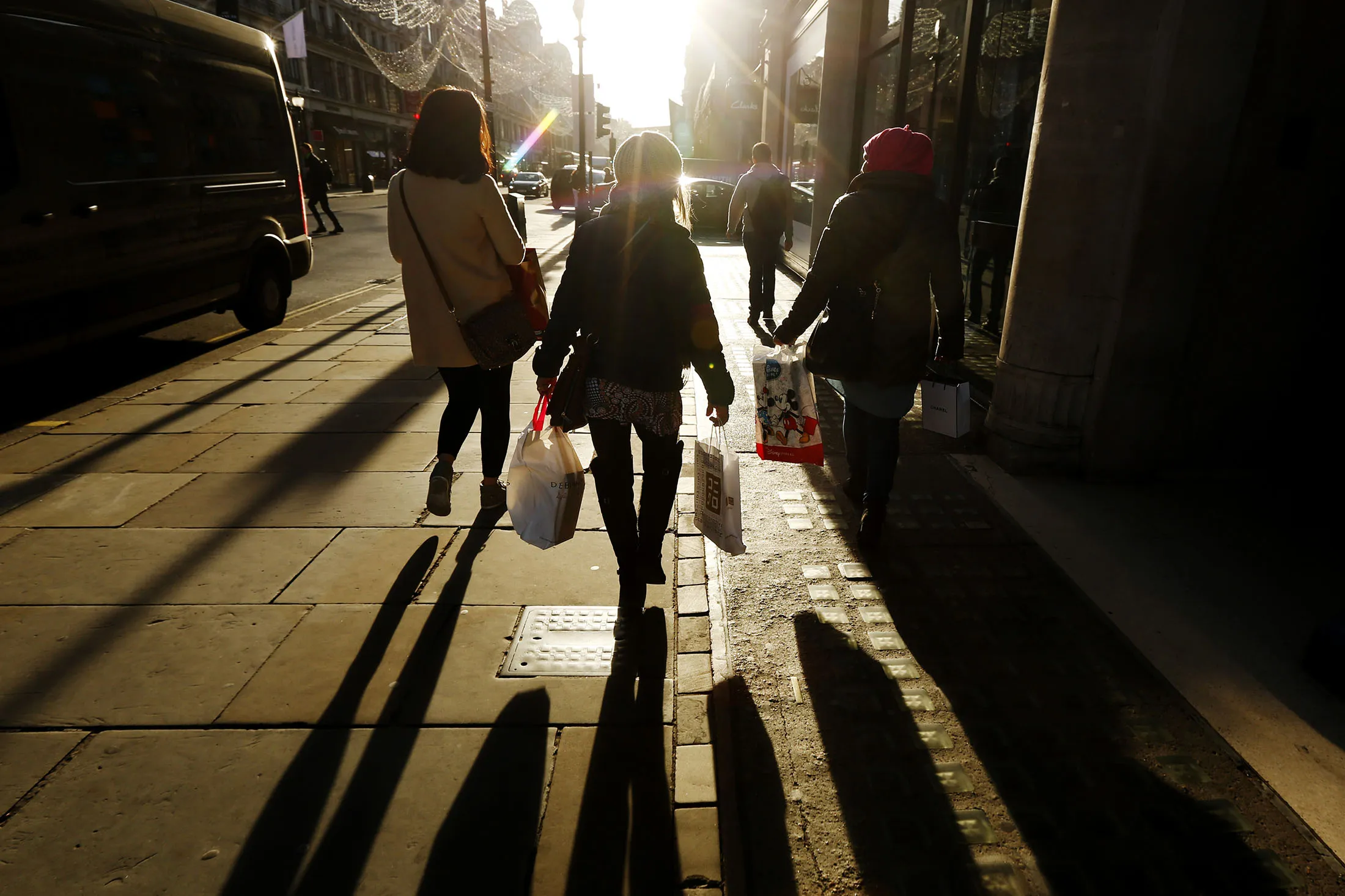 Shoppers carry multiple branded shopping bags on Regent Street in London.
