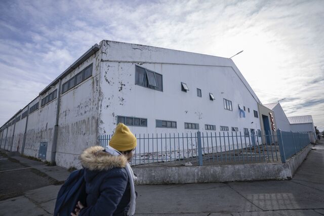 A homecare worker walks past a recently shuttered textile factory in Rio Grande.