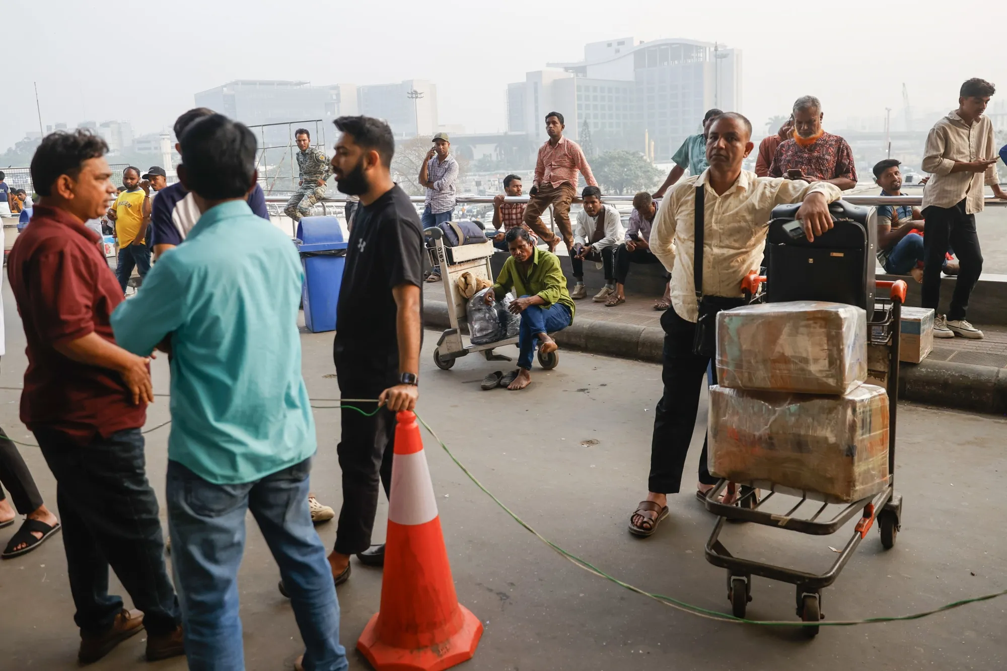 Passengers and their relatives wait outside a terminal after several flights to Middle Eastern destinations are canceled, in Dhaka, Bangladesh, earlier in March. 