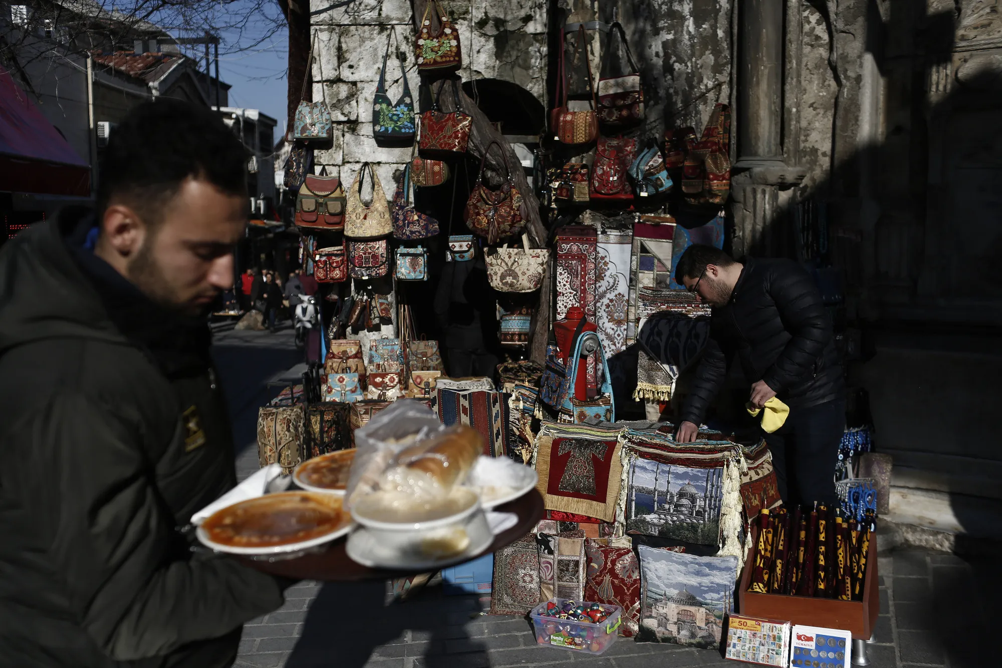 A restaurant employee carries a tray of food outside the Grand Bazaar.&nbsp;