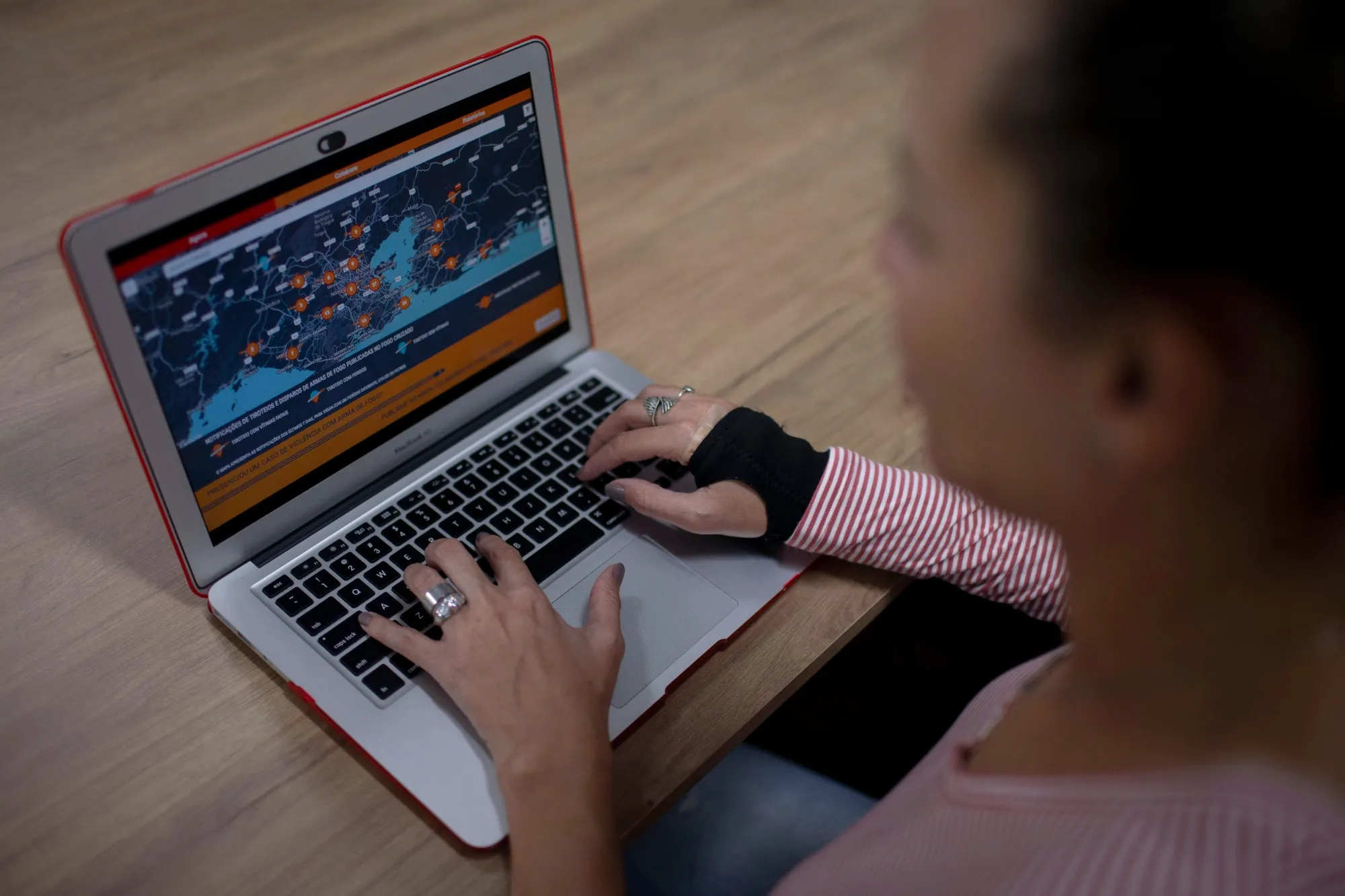 Fogo Cruzado founder Cecilia Oliveira shows the Fogo Cruzado App in her laptop in Rio de Janeiro in 2018.