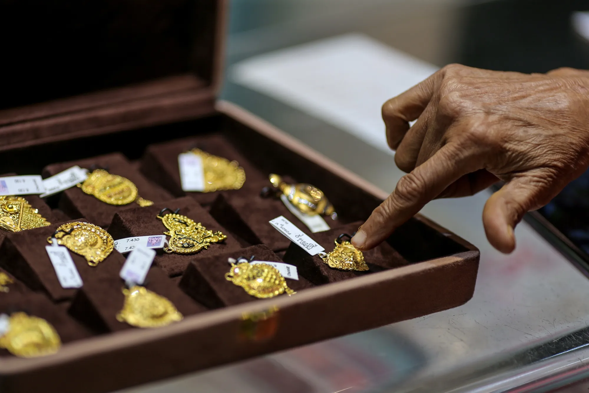 A customer looks at gold jewelry inside a store at Zaveri Bazaar in Mumbai. 