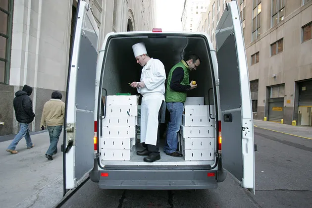 The chef of Eleven Madison Park restaurant in New York checks the items for sale in the back of a van selling produce.