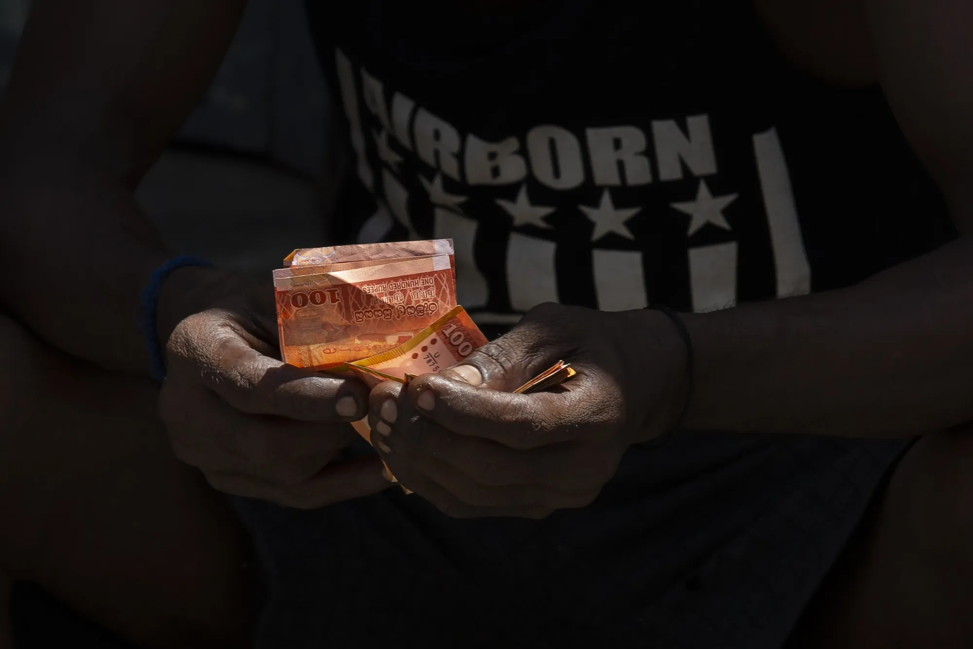 A man counts Sri Lankan rupee banknotes at a wholesale market in Colombo, Sri Lanka, on Monday, May 16, 2022. Sri Lanka has been rattled by power cuts, food shortages, and a currency in free fall, which fueled protests and pushed Prime Minister Mahinda Rajapaksa to resign.