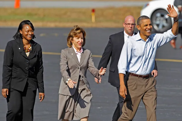 President Obama, with Senator Kay Hagan (D-N.C.), center, and Asheville Mayor Terry Bellamy, left, waves upon his arrival at Asheville Regional Airport in 2011