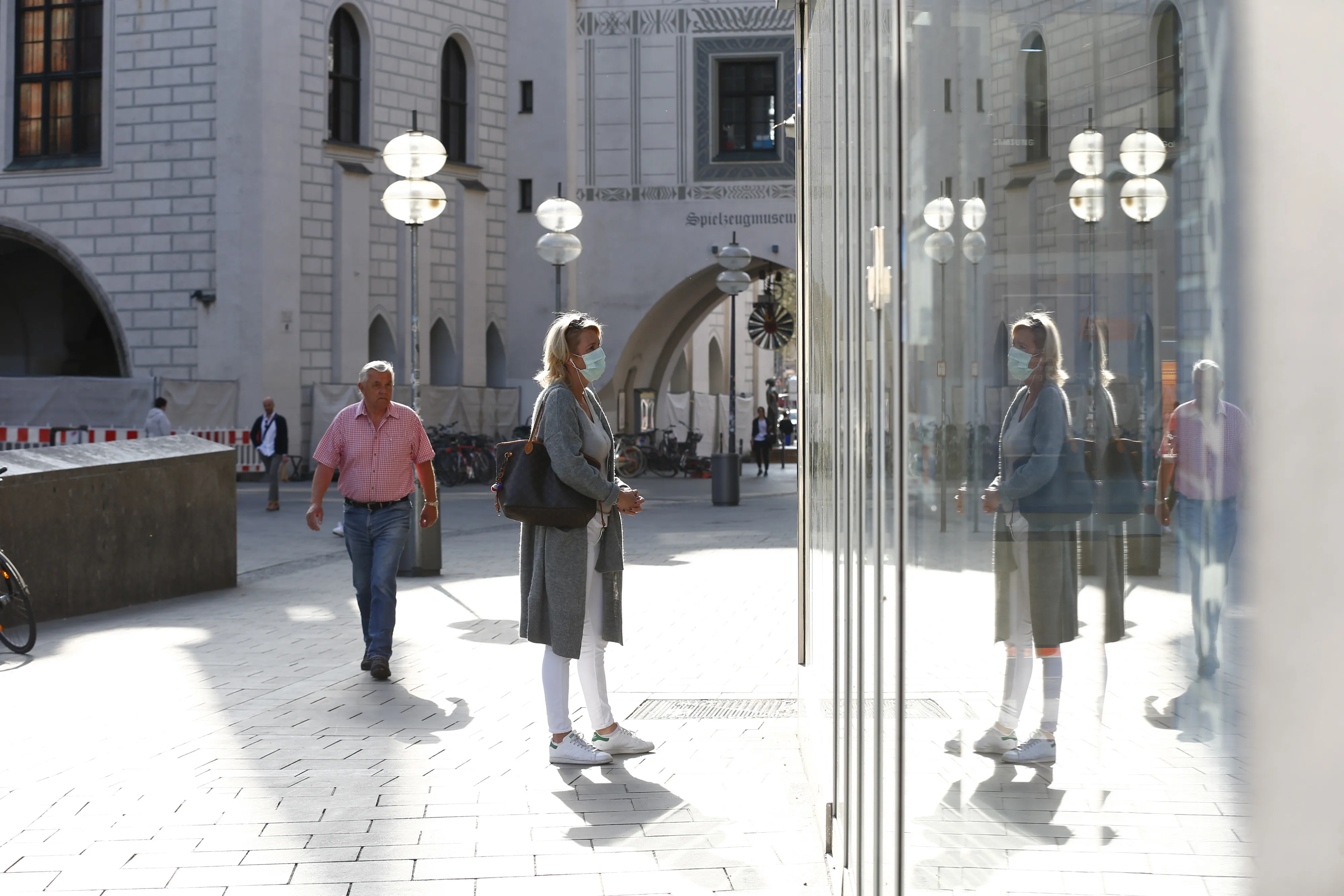 A pedestrian wearing a protective face mask looks inside a closed store during coronavirus lockdown in Munich, on April 17.