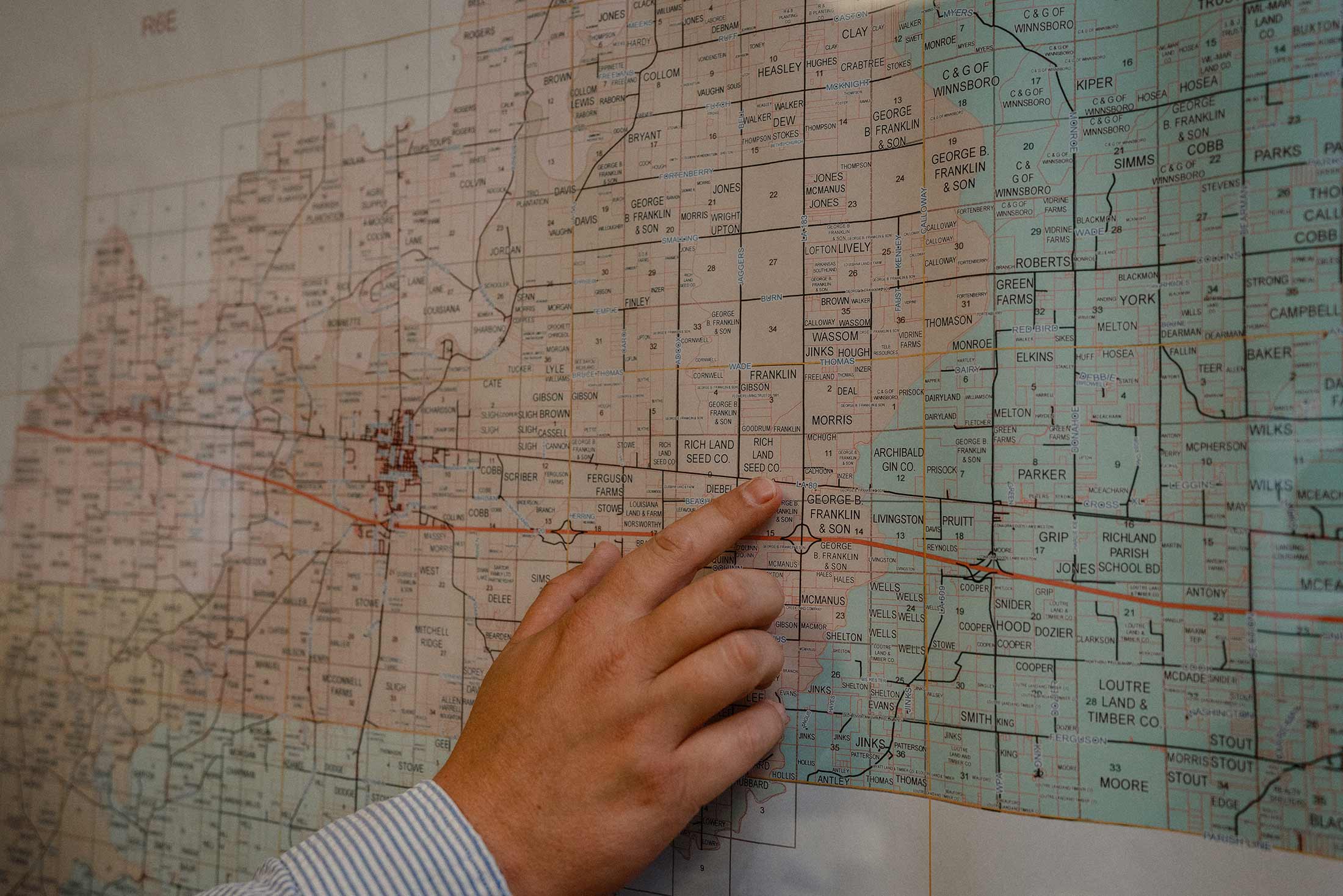 Scott Franklin's hand points to the data center site on a map detailing local landownership. His family owns much of the land surrounding the site and has sold several large parcels already.