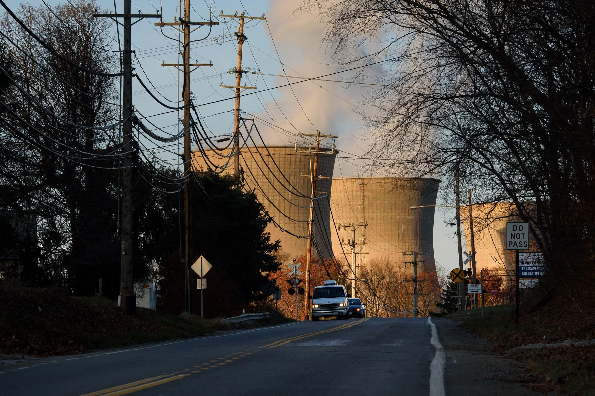 Vehicles drive along a road near the Bruce Mansfield coal-fired power plant in Shippingport, Pennsylvania.