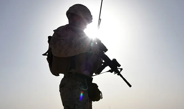 A US Marine watches Afghan Commandos take part in a combat training exercise.