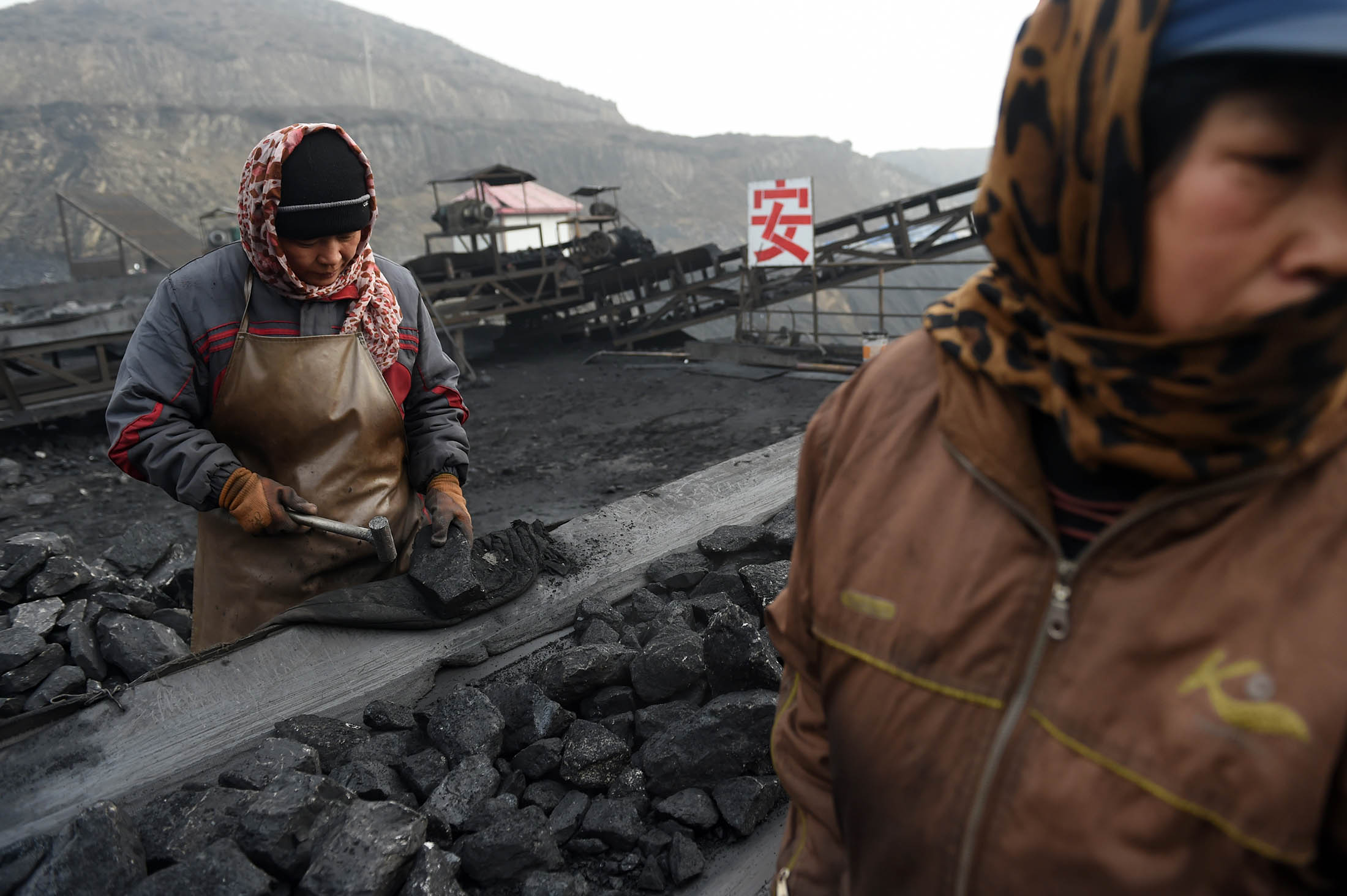 Workers sort coal on a conveyer belt, near a coal mine at Datong, in China's northern Shanxi province. China will suspend the approval of new mines starting in 2016 and will cut coal’s share of its energy consumption to 62.6 percent next year.
