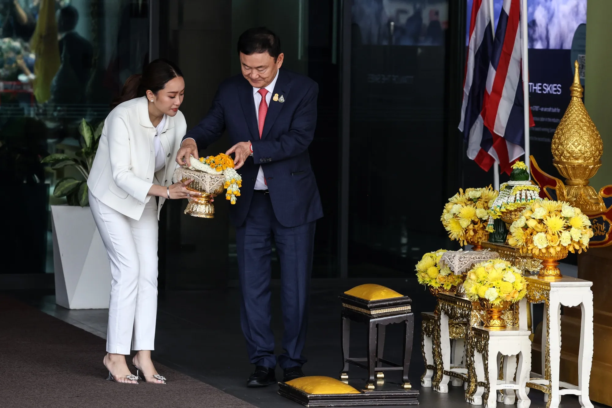 Paetongtarn Shinawatra and her father Thaksin prepare to lay flowers before a portrait of King Maha Vajiralongkorn following Thaksin’s return from self-exile in Bangkok in 2023.