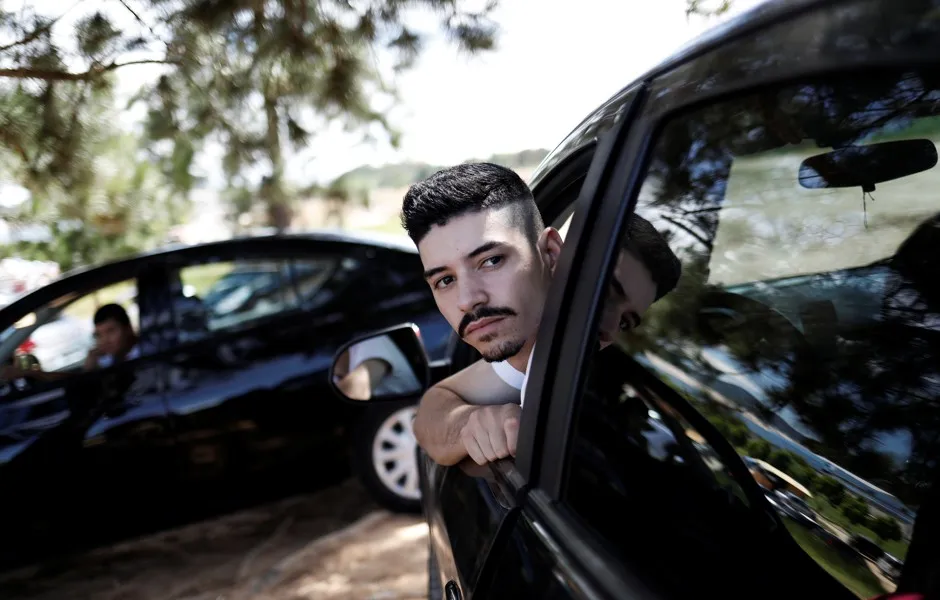Uber drivers sit in their cars waiting for passengers. 