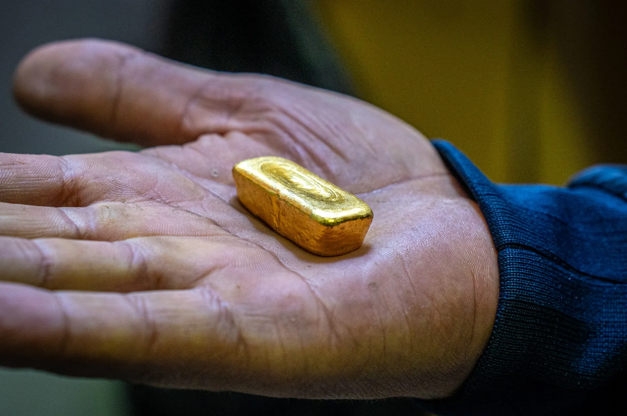 A worker holds a processed gold ingot at a refinery operation in Marmato, Colombia.