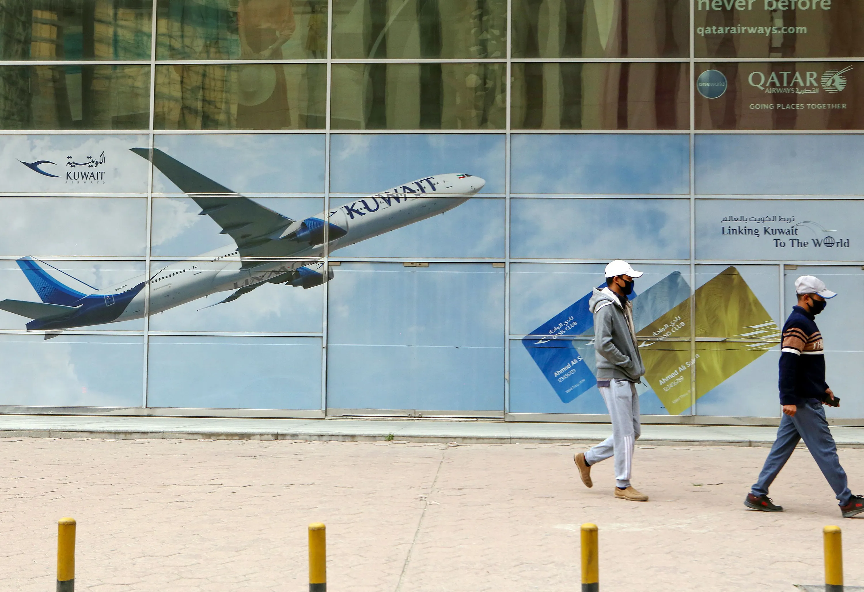 Pedestrians walk past&nbsp;a billboard for Kuwait Airways in Kuwait City on March 14.