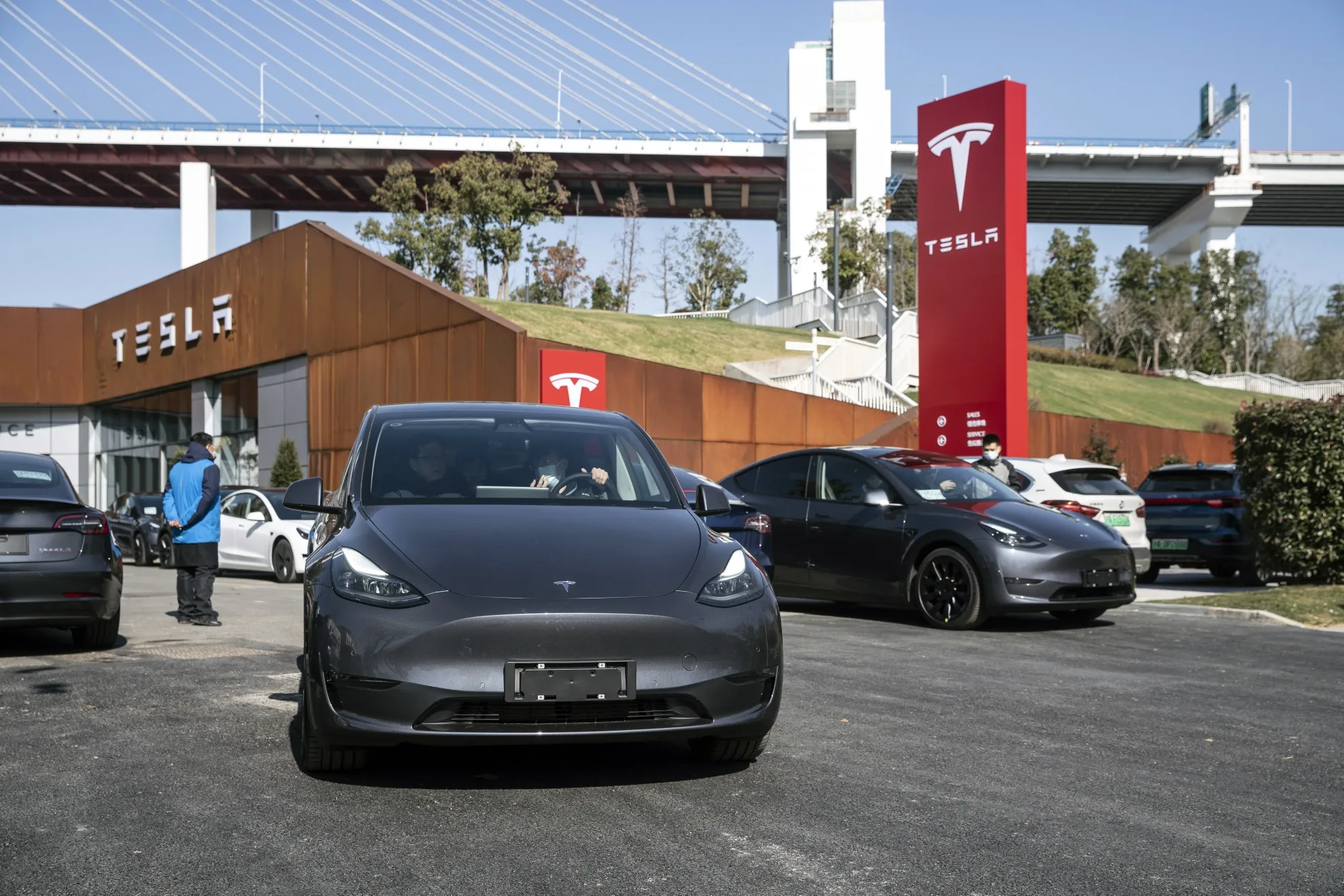 A customer and a sales assistant sit inside a Tesla Inc. Model Y electric vehicle during a test drive at the automaker's showroom in Shanghai.