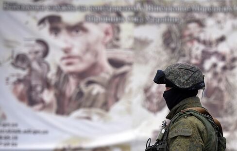A Soldier Stands in front of a Recruitment Poster