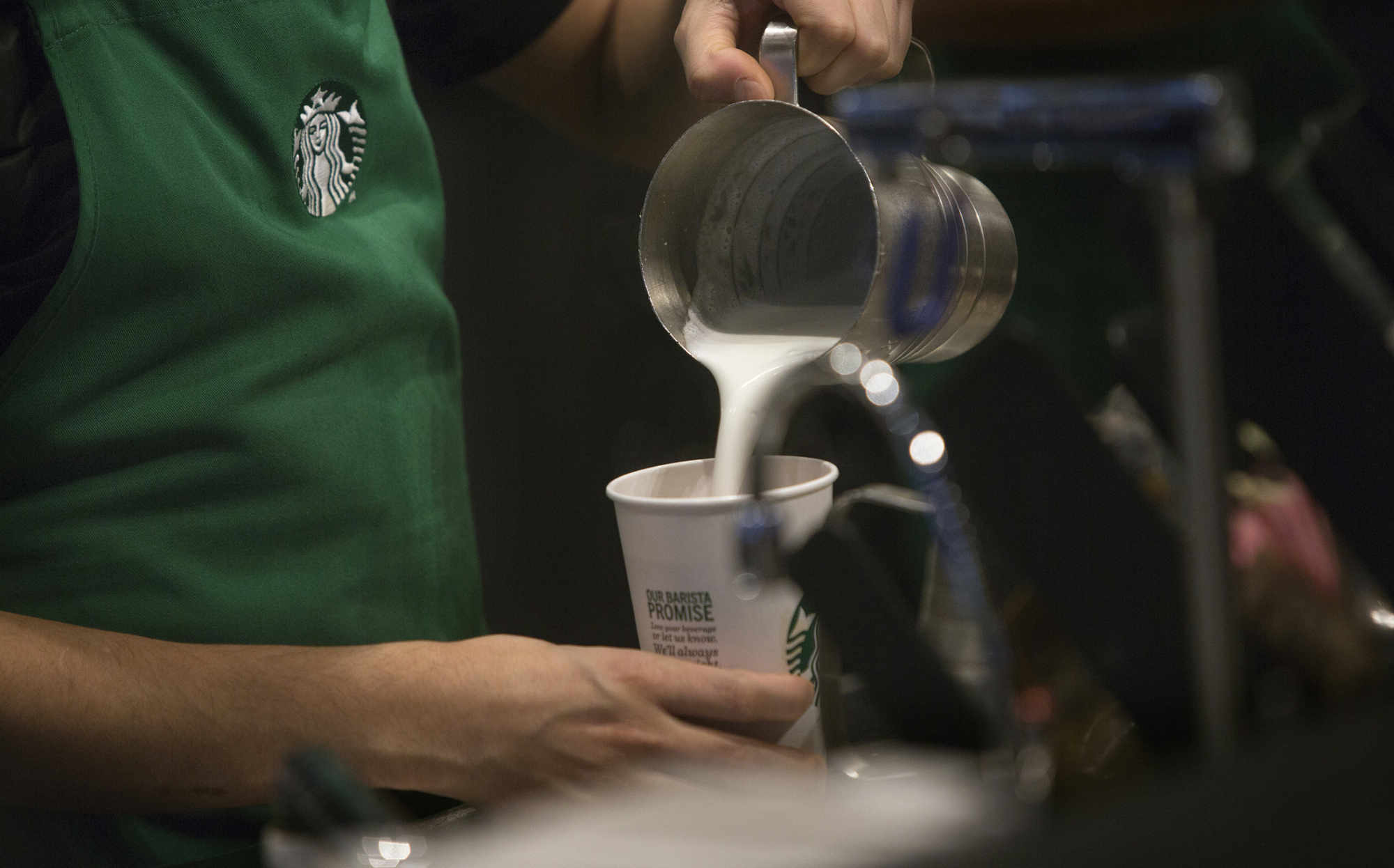 A barista pours frothed milk into a drink inside a Starbucks Corp. coffee shop in New York on Jan. 19, 2016.

