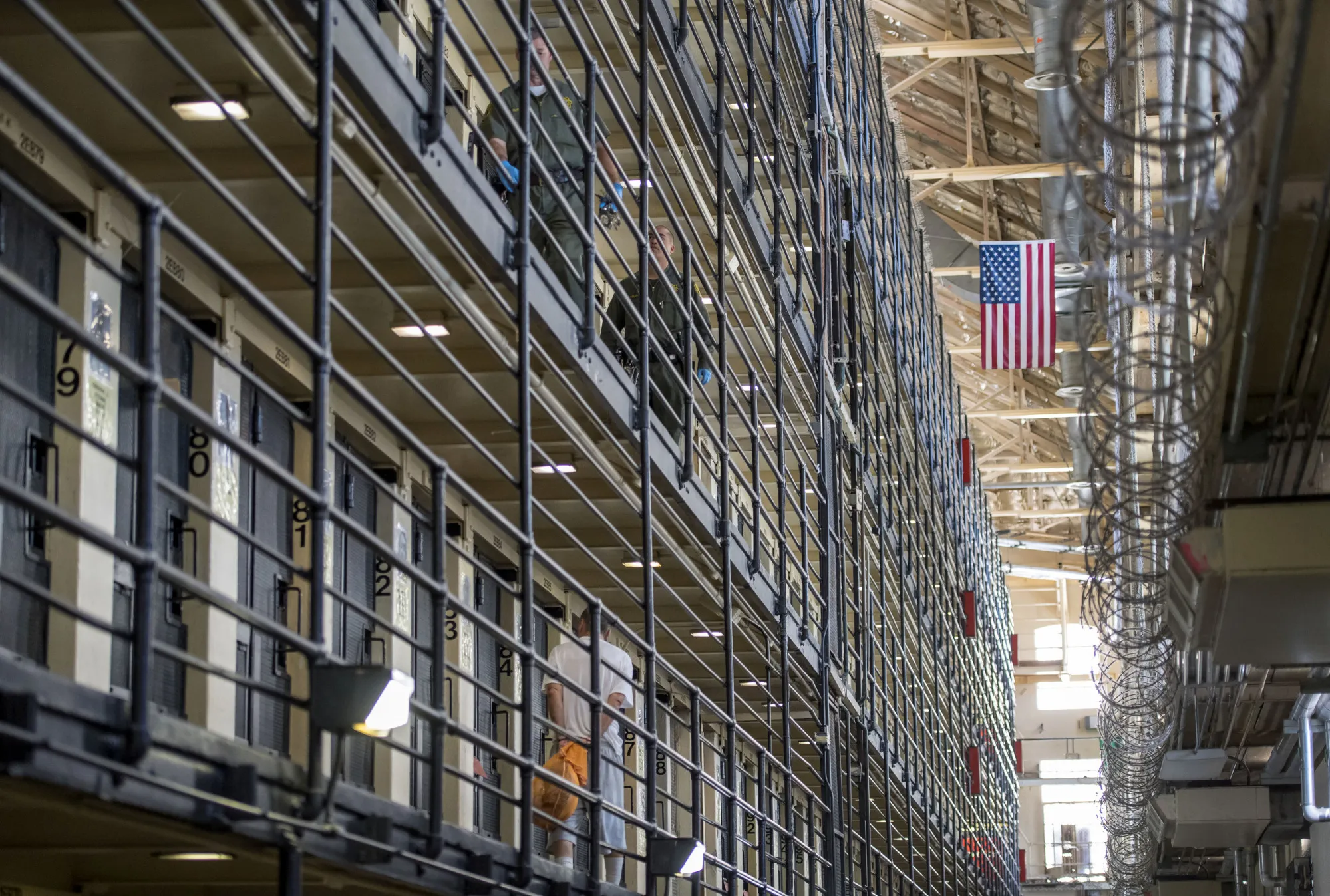 An inmate walks to his cell as corrections officers patrol at San Quentin State Prison in San Quentin, California, U.S., on Tuesday, Aug. 16, 2016. San Quentin, home to the state's only death row, houses 725 condemned inmates. On the November 8th California ballot voters have the chance to abolish the death penalty or speed up the process.