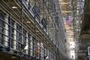 An inmate walks to his cell as corrections officers patrol at San Quentin State Prison in San Quentin, California, U.S., on Tuesday, Aug. 16, 2016. San Quentin, home to the state's only death row, houses 725 condemned inmates. On the November 8th California ballot voters have the chance to abolish the death penalty or speed up the process.