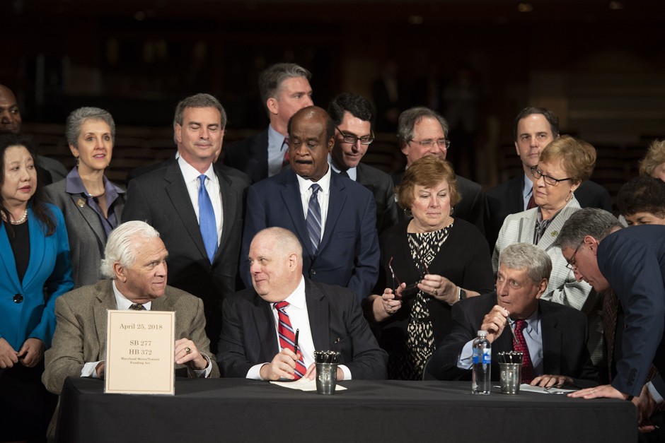 Maryland Governor Larry Hogan, center, signs bills for Metro funding and Amazon incentives in Rockville on April 25.