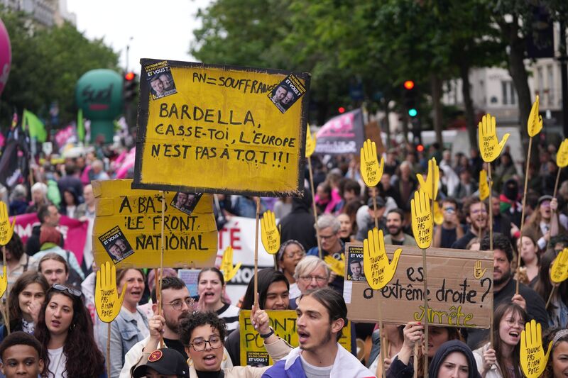 Protesters hold banners during a demonstration against the far-right and racism in central Paris, June 15, 2024.