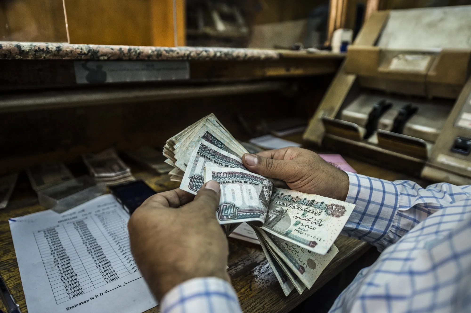 A man counts Egyptian pounds in Cairo, Egypt.&nbsp;
