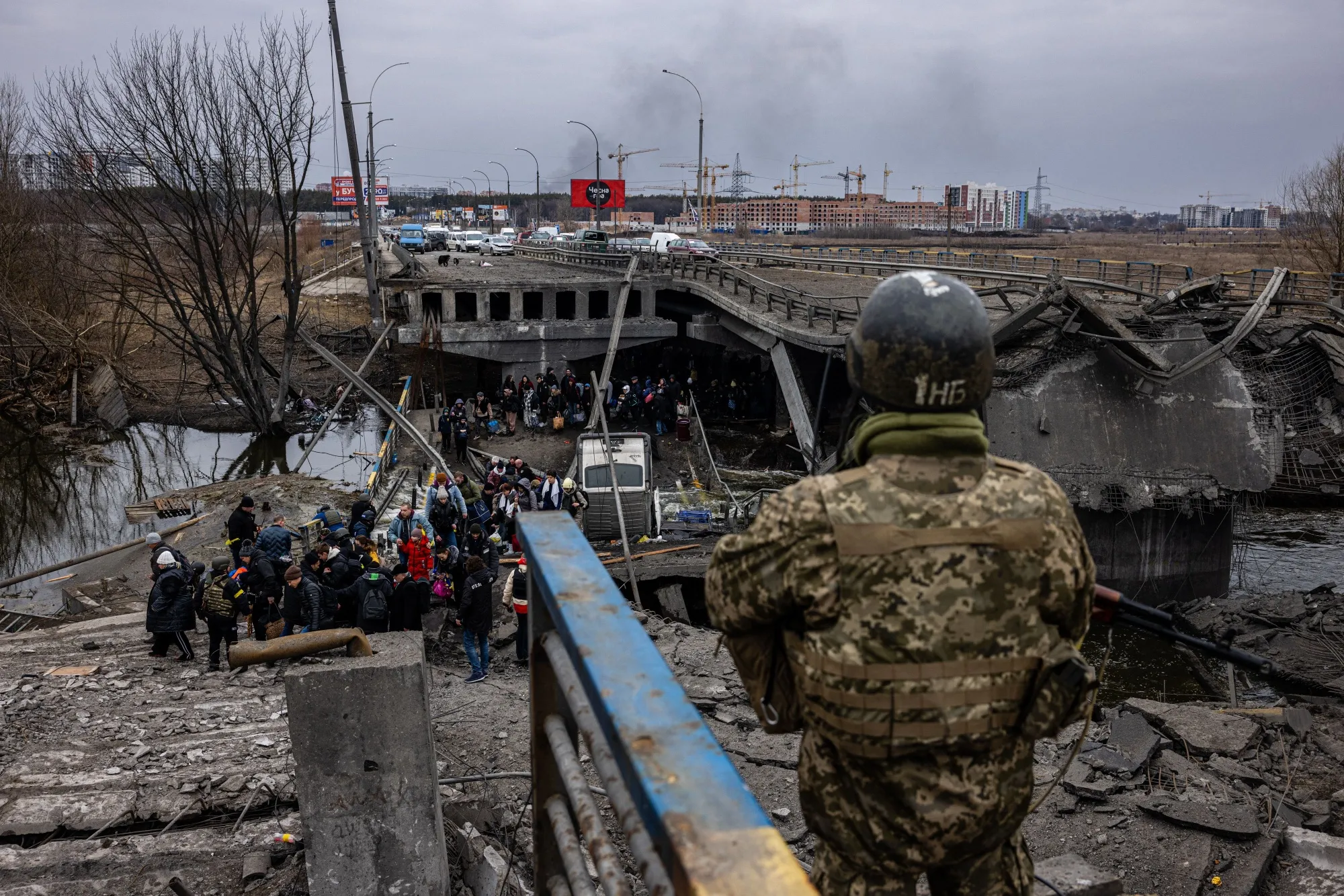 Residents&nbsp;cross a destroyed bridge in&nbsp;Irpin, near Kyiv, on March 7.