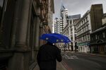 A pedestrian holds an umbrella, featuring the design of the EU flag, as he shelters from the rain in City of London financial district in London.