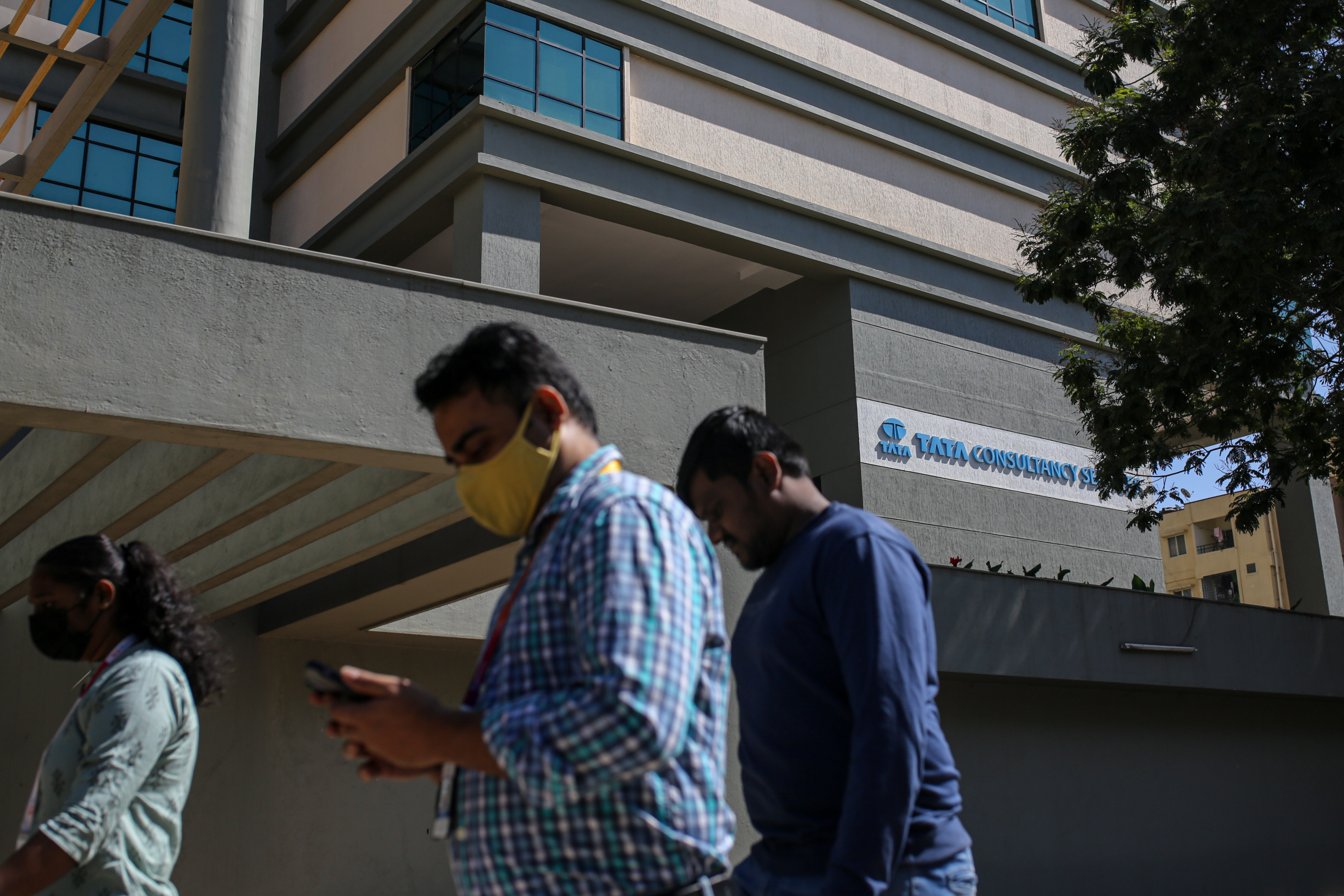 Pedestrians near a Tata Consultancy Services Ltd. office building in the Electronic City area of Bengaluru, India. Photographer: Dhiraj Singh/Bloomberg