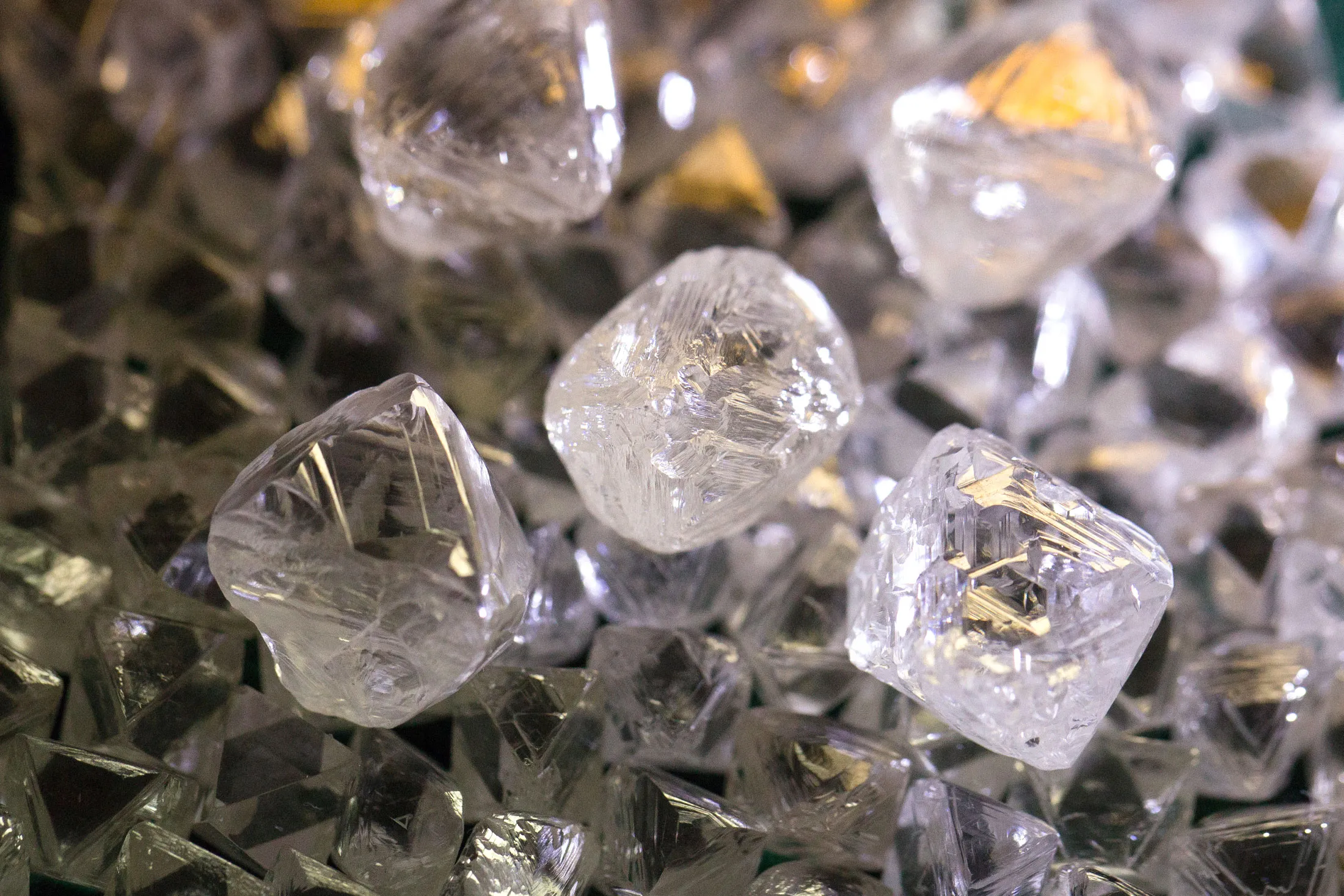 Rough diamonds sit on a display table at the Yakutsk Diamond Trading Enterprise (YaPTA), operated by Alrosa PJSC, in Yakutsk, Russia, on Wednesday, Feb. 17, 2016. The world's two biggest diamond miners, De Beers and Alrosa, just sold $1 billion worth of gems and it's making smaller rivals nervous.
