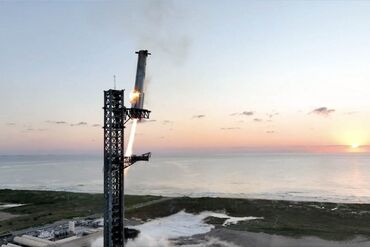 Starship's Super Heavy rocket booster is caught mid-air during the fifth flight test in Texas